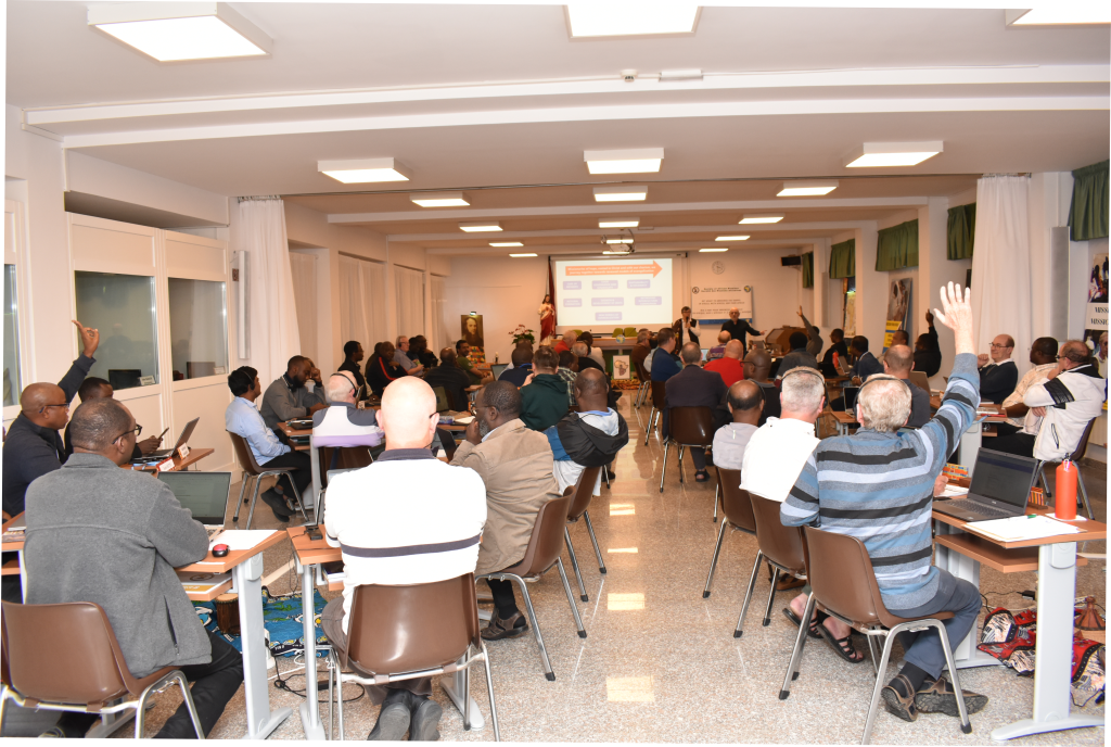 Delegates participate in a plenary session of the 22nd SMA General Assembly at Rocca di Papa, Rome, with some raising their hands during discussions on May 27, 2025.